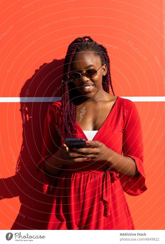 Cheerful black woman using smartphone female african american street happy mobile smile cheerful trendy style city gadget device urban sunglasses cellphone