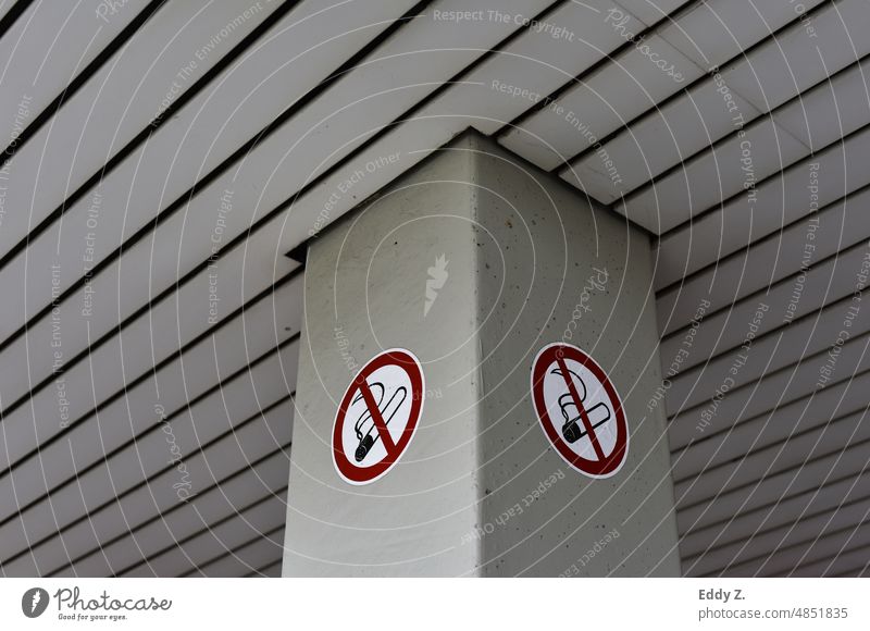 No smoking sticker on a gray column. The area where people are not allowed to smoke. Smoking stickers Column range interdiction Signs and labeling