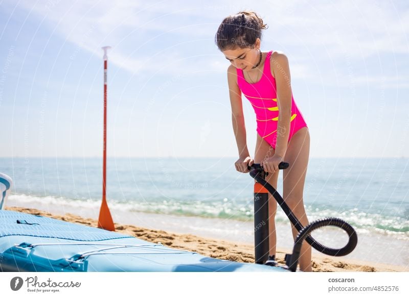 Little girl inflating a paddle surf on the beach active activity adventure balance board boarding child childhood exercise family friends fun happy healthy