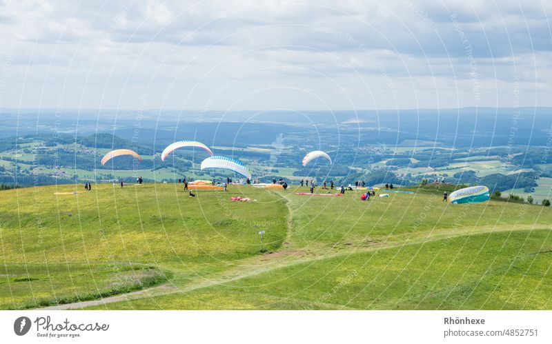 Paragliders on the Wasserkuppe wait for the perfect wind Hang gliding Hang glider Sky Flying Exterior shot Colour photo Wind Day Clouds Copy Space top Playing