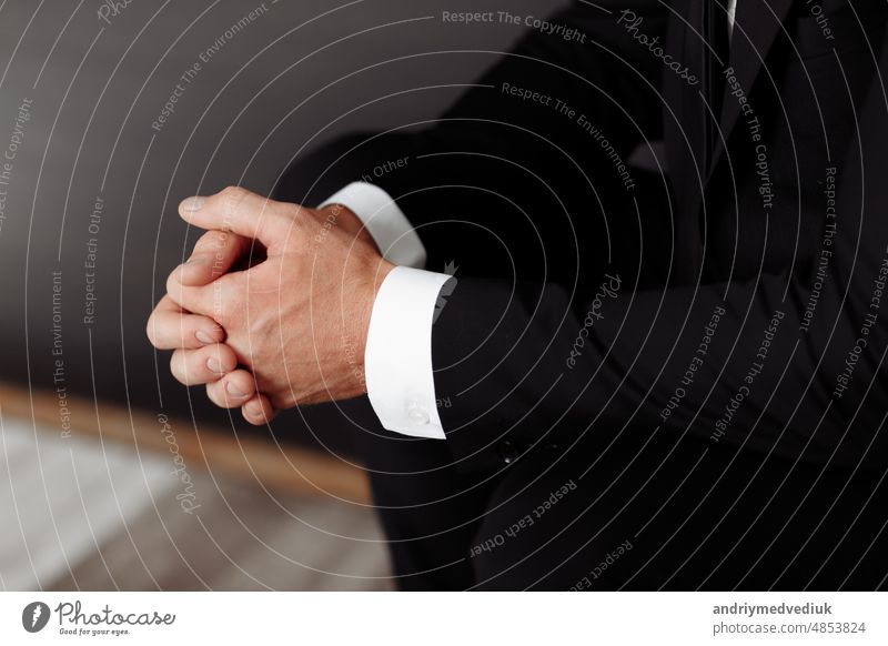 Close up of male clasped hands clenched together, businessman preparing for job interview, concentrating before important negotiations, thinking or making decision, business concept