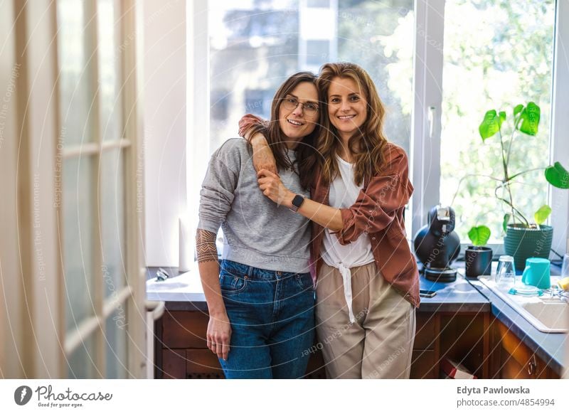 Portrait of affectionate lesbian couple embracing at home same sex couple adult apartment attractive beautiful bonding dating couple enjoyment family female