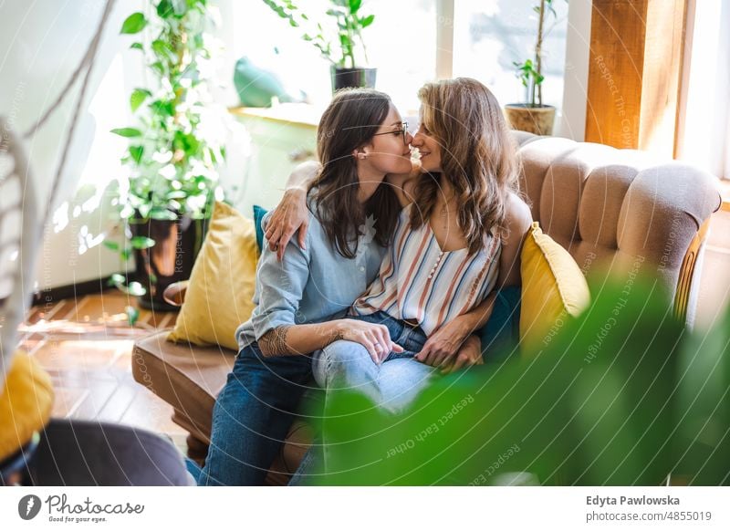 Lesbian couple in love relaxing on the sofa at home same sex couple adult apartment attractive beautiful bonding dating couple enjoyment family female