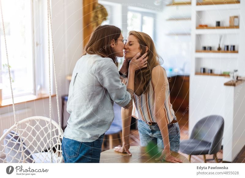 Lesbian couple kissing in their home same sex couple adult apartment attractive beautiful bonding dating couple enjoyment family female gay couple gay women