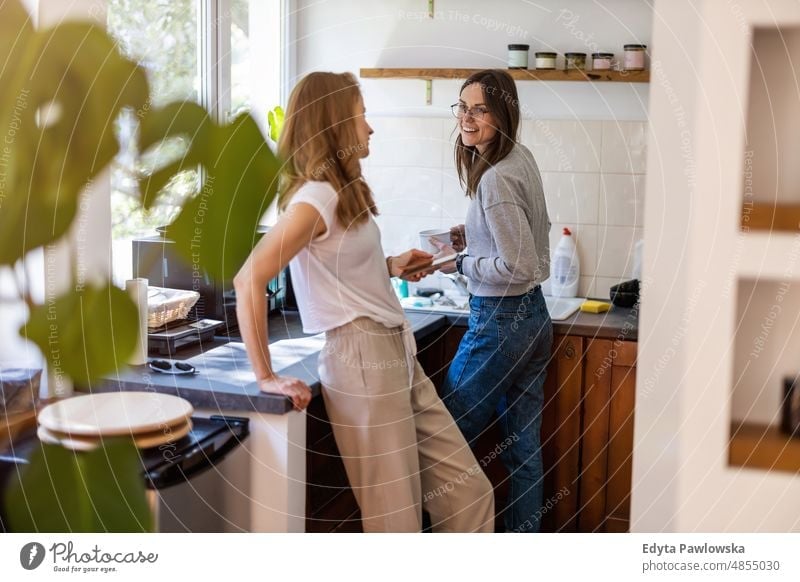 Two women spending time in the kitchen at home same sex couple adult apartment attractive beautiful bonding dating couple enjoyment family female gay couple