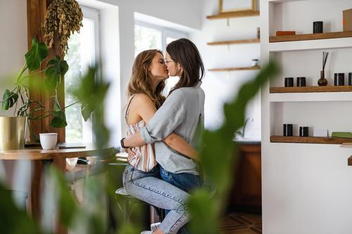 Lesbian couple kissing in their home same sex couple adult apartment attractive beautiful bonding dating couple enjoyment family female gay couple gay women