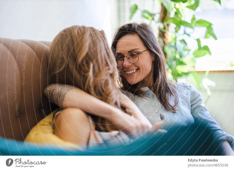 Lesbian couple in love relaxing on the sofa at home same sex couple adult apartment attractive beautiful bonding dating couple enjoyment family female