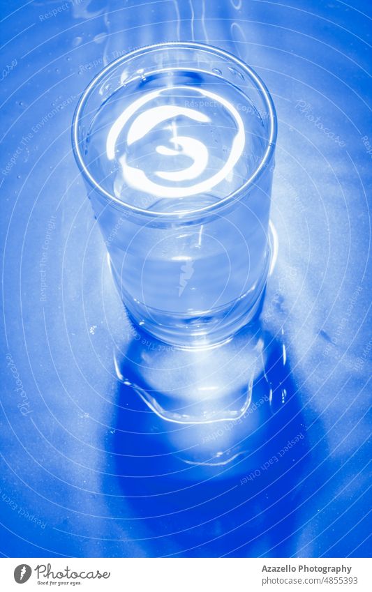 Glass of cold water in blue monochrome. abstract still life minimalism aqua background beverage black blur blurry bubble clean clear concept cool dark diet