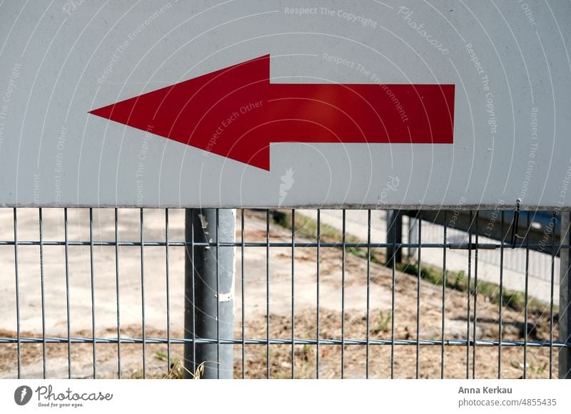 Left long-a red arrow attached to a metal grate shows the way Red Arrow Signage in a certain direction Direction Reddish white groundbreaking Left arrow