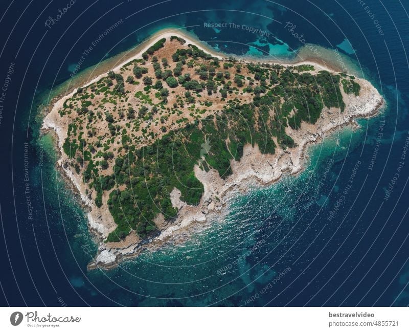 Drone view of a small island strip with green vegetation and rocky coast in the Mediterranean at Chalkidiki peninsula, Greece. Mediterranean landscape drone
