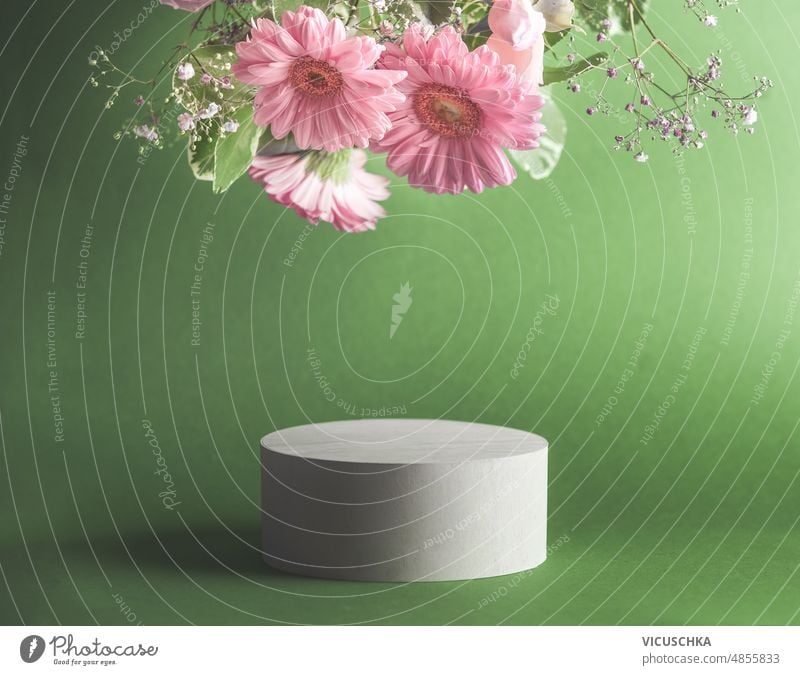 Beautiful minimal modern product display with podium and hanging pink flowers at green background. Place for beauty products or marketing campagne beautiful
