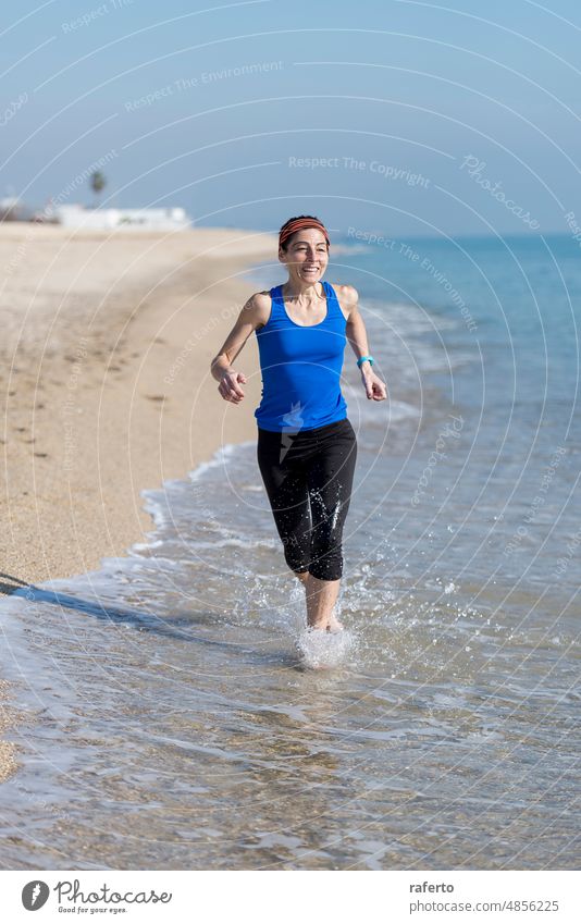 Front view of women jogging on beach close to water person fitness runner sport ponytail woman female exercise jogger summer girl healthy outdoor sea active