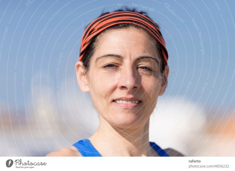 Headshot Close-up portrait of a casually runner woman smiling, beach person female head shot headband looking at camera outdoors adult beautiful young happy