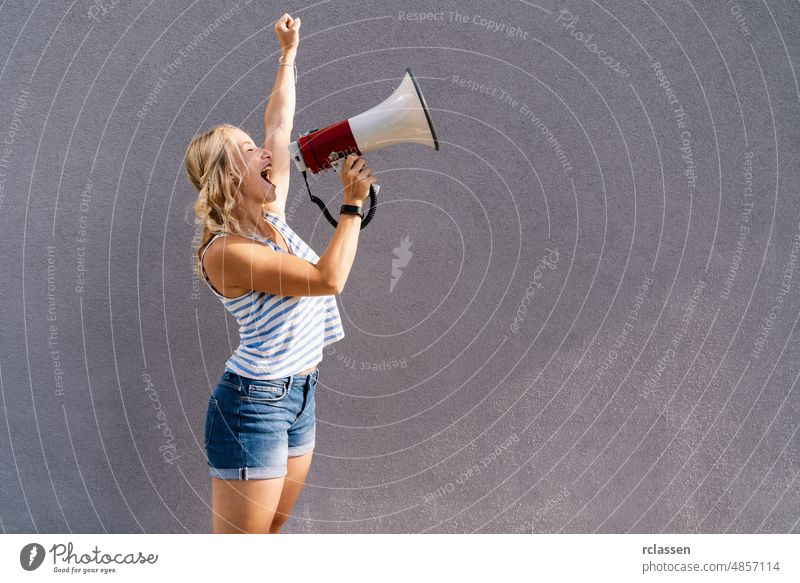 young blond woman shouting on a megaphone. copyspace for your individual text. business concept image climate public girl change speaker loud loudspeaker