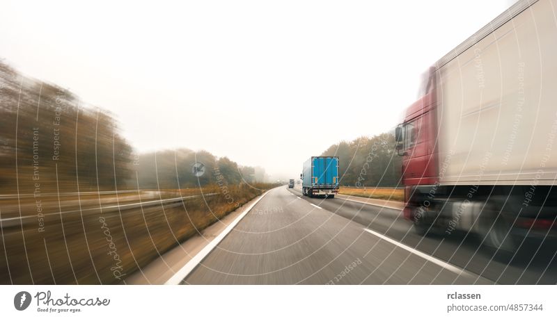 Trucks driving on the highway turning towards the horizon in an autumn landscape with mist, copyspace for your individual text. motorway car road engine