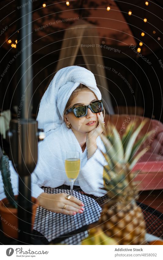 Woman in towels drinking cocktail on terrace woman morning patio hobby leisure juice beverage feminine summer glass table female sunglasses style summertime