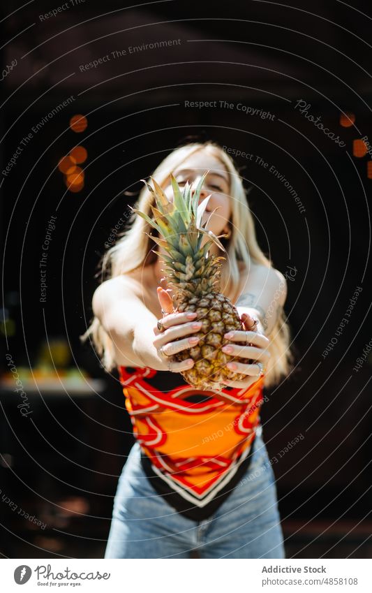 Cheerful woman with pineapple terrace hold style fruit healthy food exotic tropical natural vitamin trendy building summer ripe organic fresh female positive