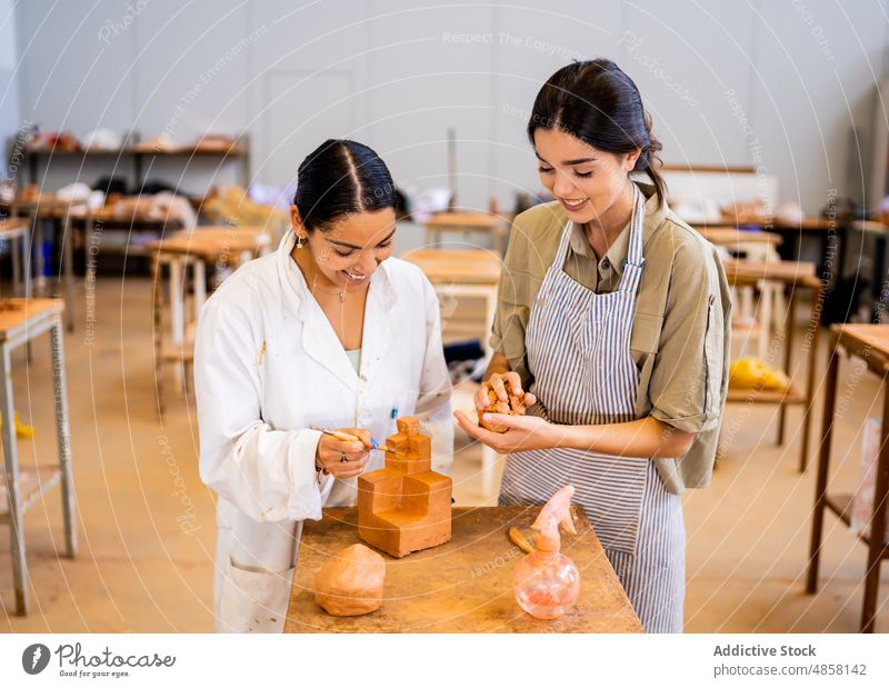 Cheerful Hispanic women working with clay together artisan pottery create geometry shape girlfriend smile female small business young hispanic ethnic skill