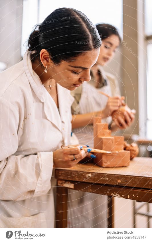 Hispanic women working with clay together artisan pottery create geometry shape girlfriend female small business young hispanic ethnic skill workshop handmade