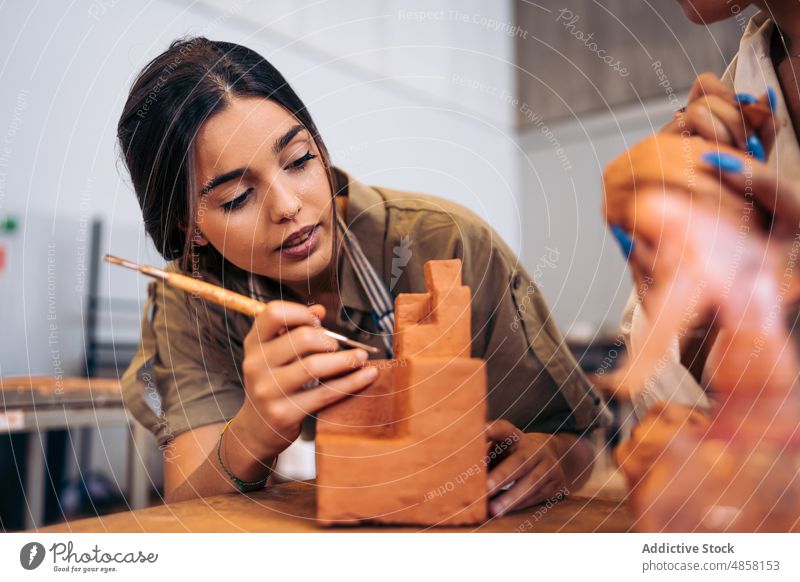 Young craftswoman carving geometric shape from clay carve geometry studio portrait creative handmade female young hispanic ethnic table artisan hobby workshop