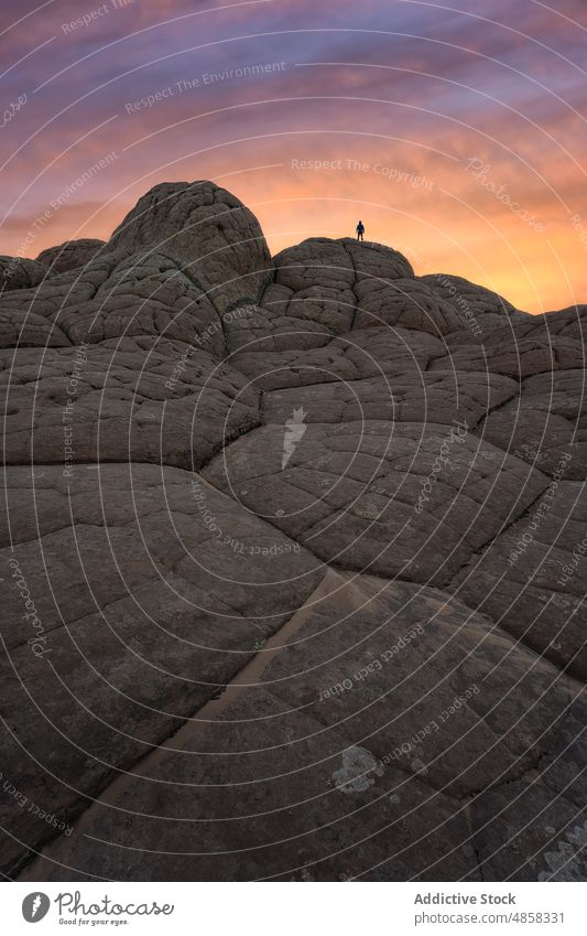 Anonymous traveler standing on stone on mountain during sunset vermillion canyon cliffs landscape arizona desert twilight usa outdoors nature monument arid sky