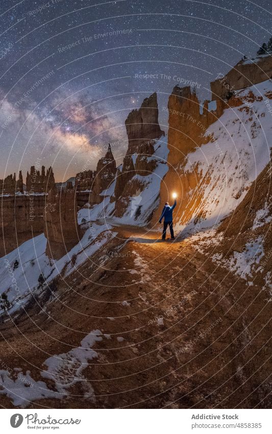 Anonymous traveler standing on snowy mountain with milky way on sky Goblin Valley canyon cliffs landscape night usa outdoors Utah nature State Park winter star
