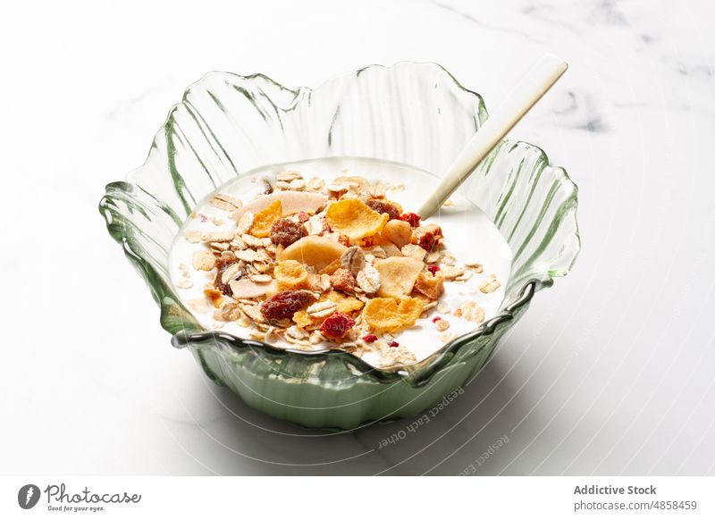 Bowl with yogurt and breakfast cereals bowl fruit food muesli spoon morning healthy lifestyle table diet organic nutrition fiber dessert fresh snack flake corn