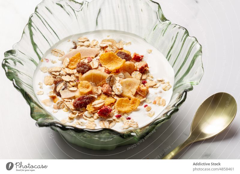 Bowl with yogurt and breakfast cereals bowl fruit food muesli spoon morning healthy lifestyle table diet organic nutrition fiber dessert fresh snack flake corn