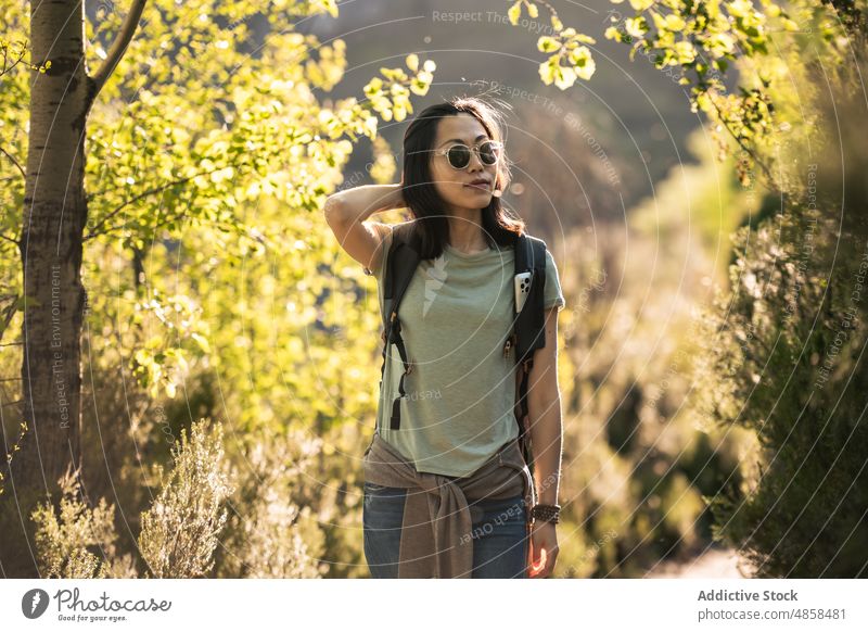 Traveling Asian woman with backpack walking in nature travel hiker trekking adventure sunglasses tourism explore journey valverde de los arroyos guadalajara
