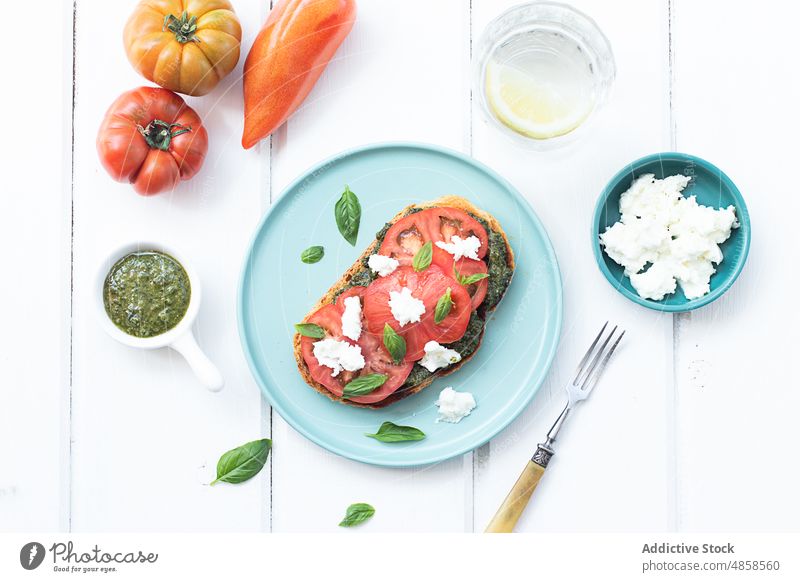 Caprese toast served on wooden table tomatoes caprese bread delicious pesto sauce oil salad snack sandwich vegetables mozzarella cheese fresh basil freshness