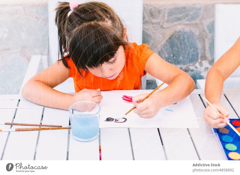 Girl painting on paper on terrace girl kid hobby art imagination childhood pastime supply craft paintbrush creative colorful practice painter pigment palette