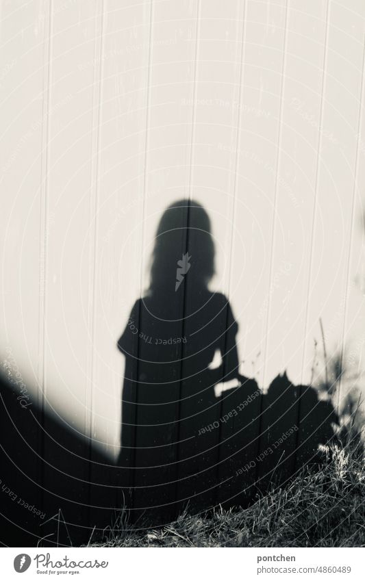 Shadow of a female child on a wall of wooden boards Child Girl Hut Wooden boards Wall (building) out Meadow black-white Sun Summer Infancy Nature