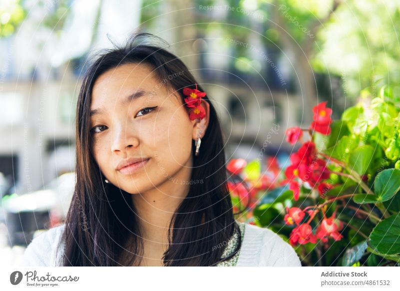 Charming Asian woman with flowers in hair portrait appearance street floral bud charming summer plant feminine style natural asian ethnic female city lady