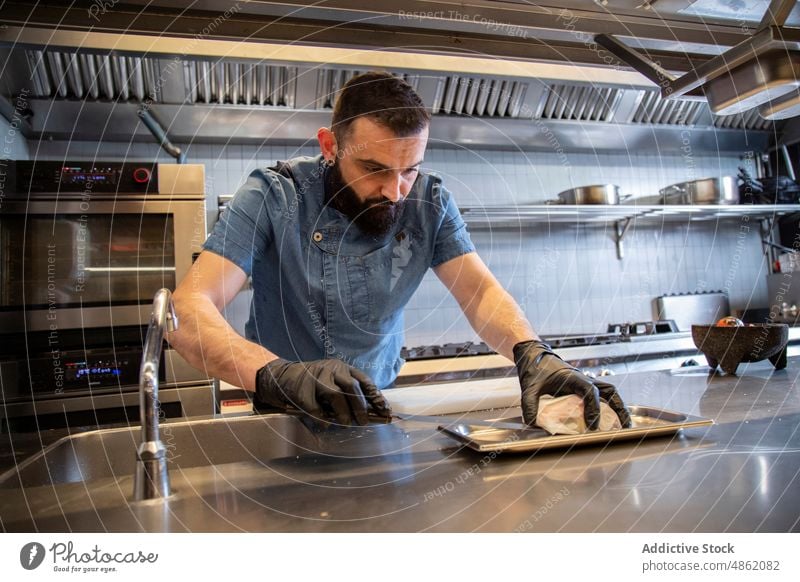 Focused Chef Placing Stuffed Meat On Baking Tray In Kitchen Knife Preparing Food Concentration Counter Modern Arranging Careful Precision Cooking Restaurant