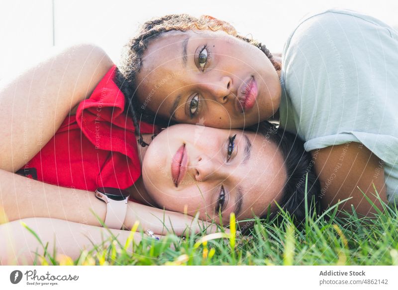 Diverse women lying on lawn friend bonding park rest pastime chill spend time spare time summer grass together girlfriend relax friendship multiracial
