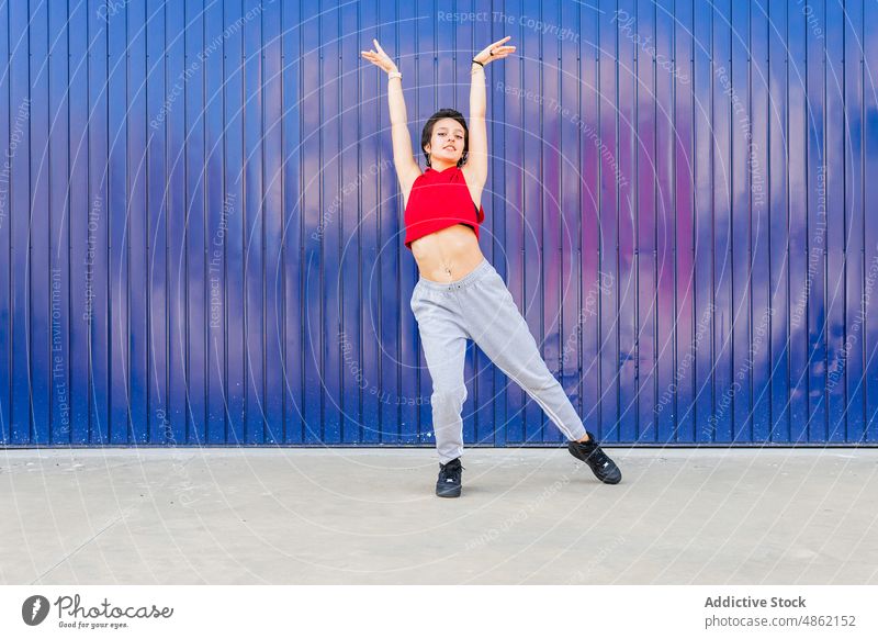 Woman dancing near blue wall woman dancer sportive street hobby city practice rehearsal choreography style female energy casual healthy lifestyle town summer