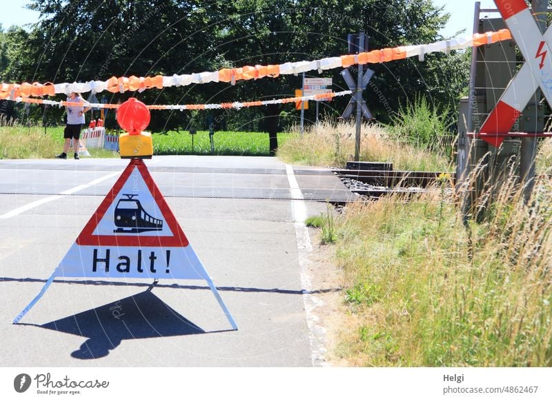 Level crossing with creative barrier Railroad crossing Road sign barrier tape blocking Train services Emergency solution Street Manual Backup peril Caution