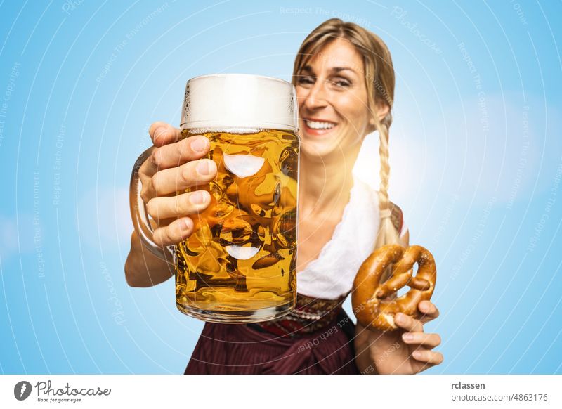 Young sexy traditional Oktoberfest visitor, wearing a traditional Bavarian dress, holding big beer mug and pretzel on blue background oktoberfest girl drink