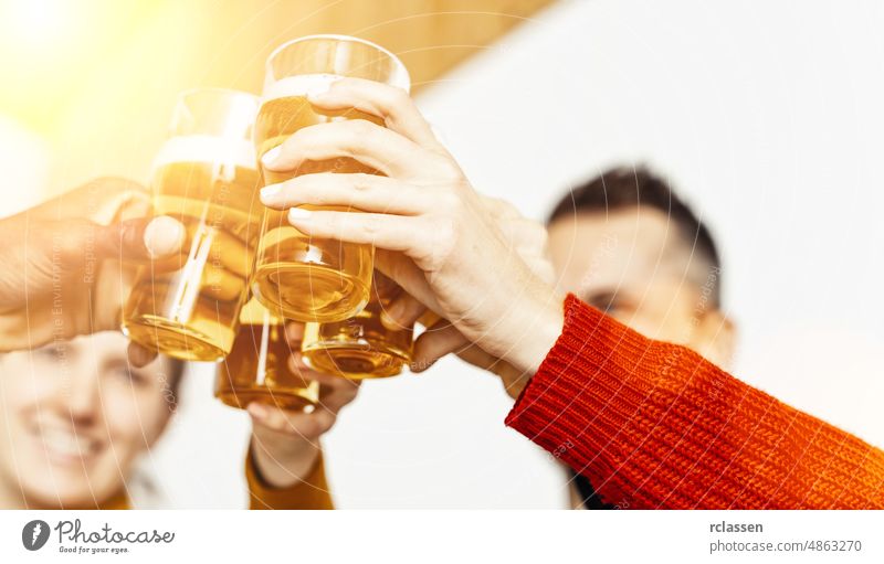 Group of friends enjoying a beer in brewery pub, Young people hands cheering at bar restaurant or at home, Friendship and youth concept image toast hipster pint