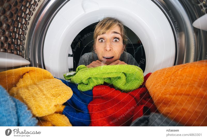 Housewife Reaching Inside a washing machine or dryer at Home view from washing machine inside tumble laundry reaching appliance caucasian chore clothes clothing