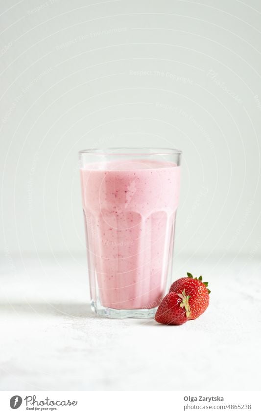Strawberry smoothie in glass. milkshake strawberry white table pink red cold summer close up selective focus drink detox mixed pastel fruit yogurt healthy