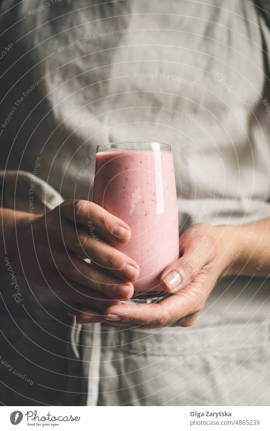 Woman hands holding a strawberry smoothie in a glass. Milkshake Strawberry Hand Participation Berries Pink Red Glass Cold Summer complete selective focus