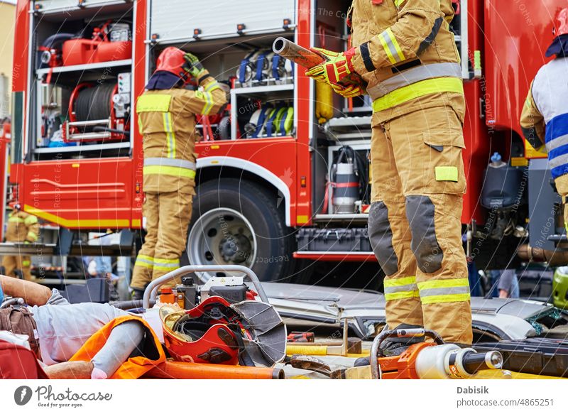 Rescuers provide first aid to the human dummy accident car crash firefighter rescue exercise demonstration extrication emergency fireman training tool exercises