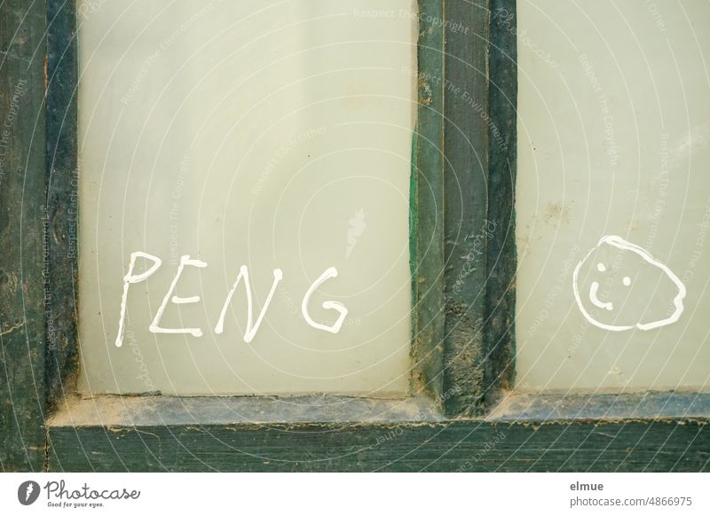 PENG and a moon face are painted in white color on the glass pane of a green wooden window bang Smiley Smiley face Window Pane Window pane Green Glass Daub
