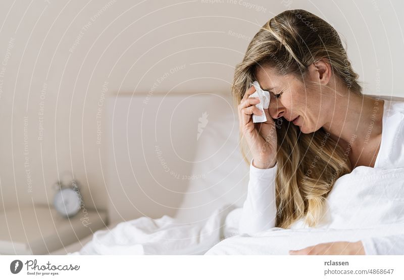 woman suffering from depression sitting on bed and crying, sneezing in tissue, sick girl  crying at home, relationship separation concept image women sad