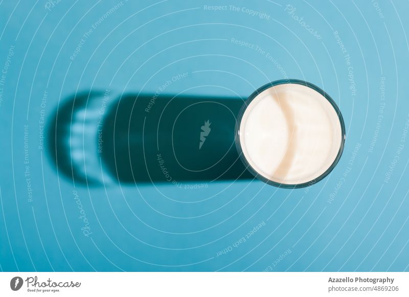 Glass of milk top view with a hard shadow on blue background. glass pastel still life minimalism drink cow farm natural organic healthcare healthy idea concept