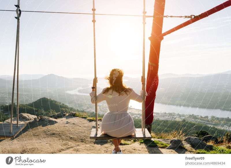 Young woman on a swing looking a beautiful landscape portrait young caucasian nature copy space viewpoint galicia spain lifestyle vacation people travel summer