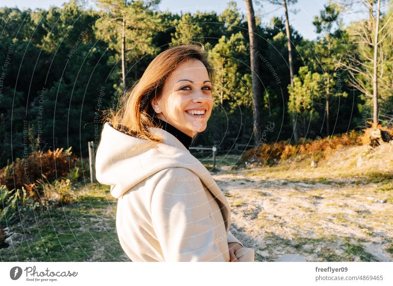 Portrait of a young woman against a forest portrait caucasian nature spanish galicia copy space looking backwards smiling happy coat autumn sunset countryside