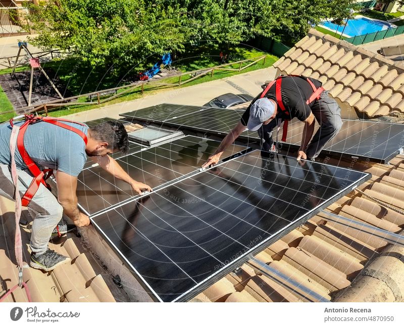 installation of solar panels on the roof of a house energy installer sun renewable man people work efficiency men industry outdoors professional occupation