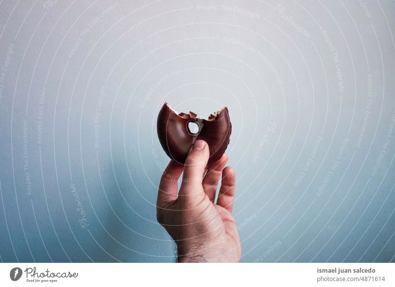 hand with a tasty chocolate doughnut donut chocolate donut food pastry breakfast brunch snack sweet food and drink yummy delicious pastries calories bakery